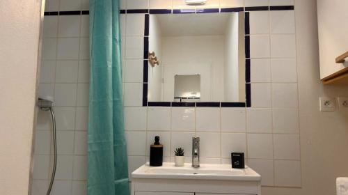 une salle de bain avec un lavabo et un miroir dans l'établissement L'idéal Central - Gare - RDC, à Mâcon