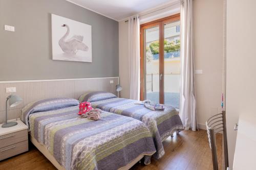 two beds in a room with a window at Residenza Marano in Cupra Marittima