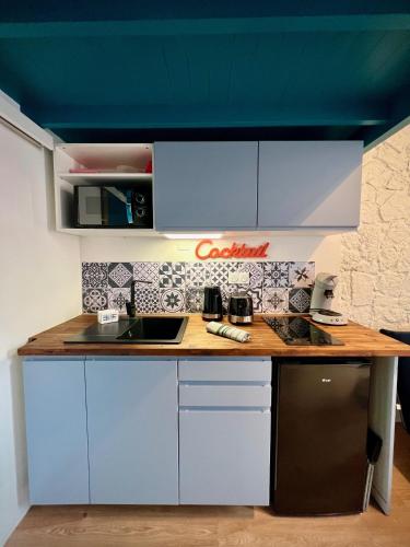 une cuisine avec des armoires blanches et un comptoir en bois dans l'établissement La Navette, à Les Sables-dʼOlonne