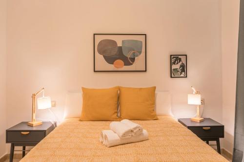 a bedroom with a bed with two night stands and two lamps at Dumonde Parking in Seville