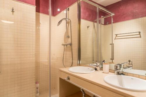 a bathroom with two sinks and a shower at Dumonde Parking in Seville