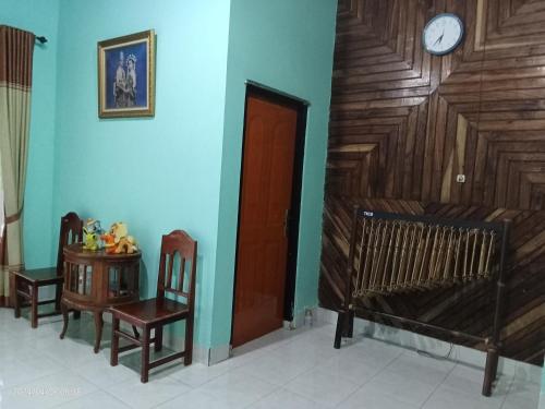 a room with a crib and a clock on the wall at Petra Homestay Bangka Leda in Ruteng