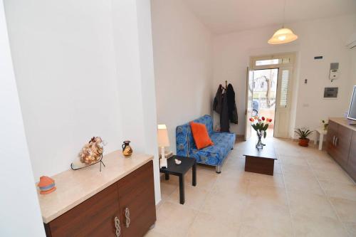 a living room with a blue chair and a couch at Casa Nzinu a soli 170 mt dal mare di Torre Colimena in Torre Colimena
