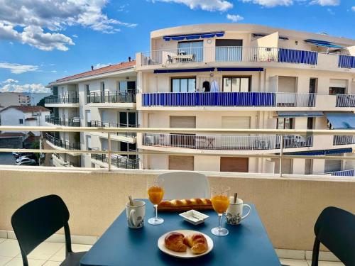 - une table avec de la nourriture sur un balcon avec un bâtiment dans l'établissement Le Lys d'Or YourHostHelper, à Cannes