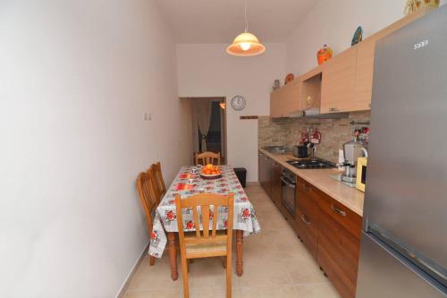 a kitchen with a table and chairs in a kitchen at Casa Nzinu a soli 170 mt dal mare di Torre Colimena in Torre Colimena