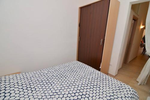a bedroom with a bed and a wooden door at Casa Nzinu a soli 170 mt dal mare di Torre Colimena in Torre Colimena