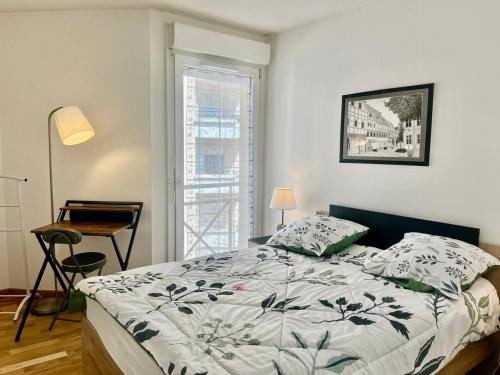 une chambre avec un lit, un bureau et une fenêtre dans l'établissement Le Lys d'Or YourHostHelper, à Cannes