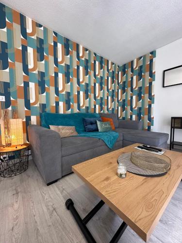 un salon avec un canapé et une table dans l'établissement LE COLORÉ - Parking gratuit - Confortable, à Pau