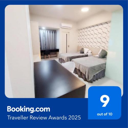 a hotel room with two beds and a tv at The Square Apartemen Service Twin Suite with WiFi NetFlix 50Inchi in Surabaya