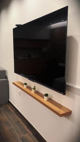 a large flat screen tv hanging on a wall at "Moon M" Apartman in Vrnjačka Banja