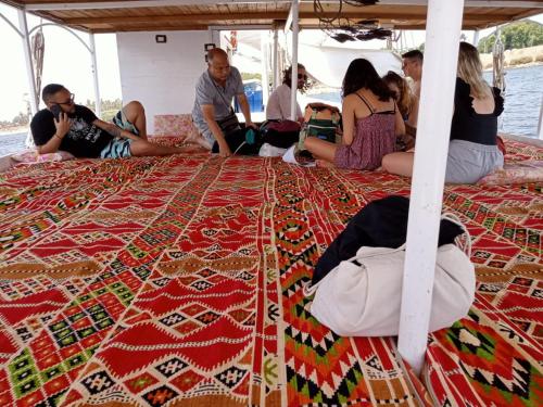 a group of people sitting on a rug on a boat at Isis Nubian Services in Jazīrat Aswān
