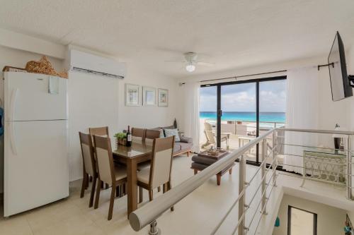 a dining room and living room with a view of the ocean at Cancun Hotel Zone -2 BR Beachfront, Bright and Spacious in Cancún