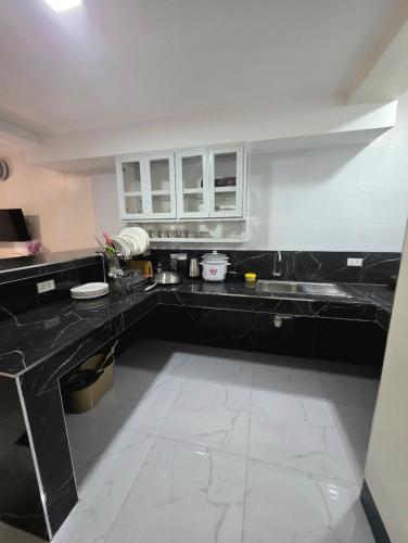 a large kitchen with black counters and white cabinets at Mamadear's Bed & Breakfast in Suizo