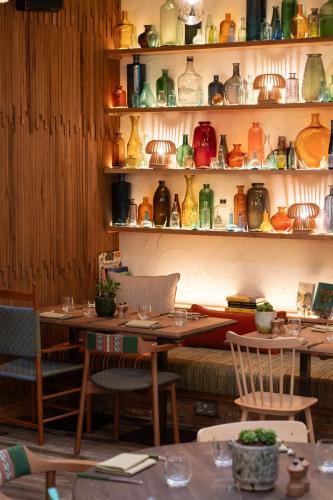 a room with tables and chairs and shelves of vases at Treehouse Hotel Manchester in Manchester