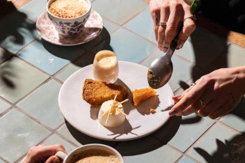 a plate of food on a table with people eating at Treehouse Hotel Manchester in Manchester