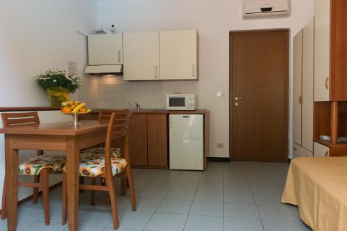 a small kitchen with a table and a refrigerator at Coccodrillo Hotel & Apartments in Varazze