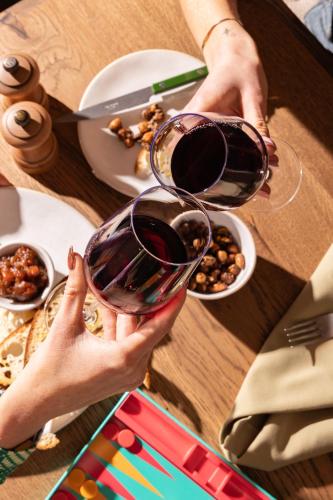 a person holding a glass of wine on a table at Treehouse Hotel Manchester in Manchester