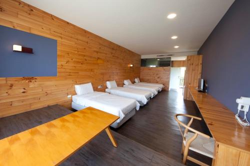 小琉球にある戀海輕旅Ocean Pride Hostelの木製の壁の部屋のベッド1列