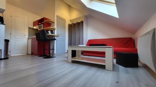 Cette chambre comprend un lit rouge et un bureau. dans l'établissement joli petit T2 proche gare et centre, à Amiens