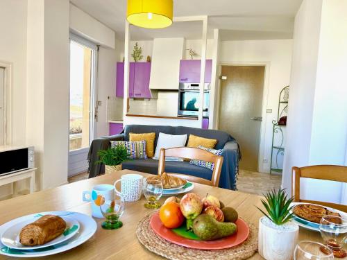 - une table avec une assiette de nourriture dans le salon dans l'établissement Le Nautile, à Les Sables-dʼOlonne