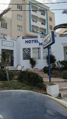 a hotel with a street sign in front of it at Hotel Mezri in Monastir
