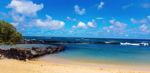 a beach with rocks and the ocean on a sunny day at "Island Time" at Plantation Hale D4 in Kapaa