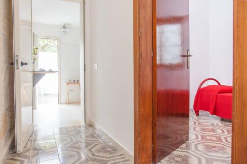 a hallway with a mirror and a red blanket at Casa Dino con accesso diretto alla Spiaggia di Punta Prosciutto in Punta Prosciutto