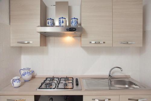 a kitchen with a sink and blue and white vases at Casa Dino con accesso diretto alla Spiaggia di Punta Prosciutto in Punta Prosciutto