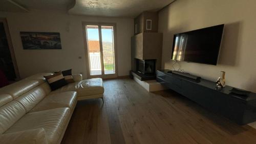 a living room with a couch and a flat screen tv at Caramaschi Verona Apartment in Negrar