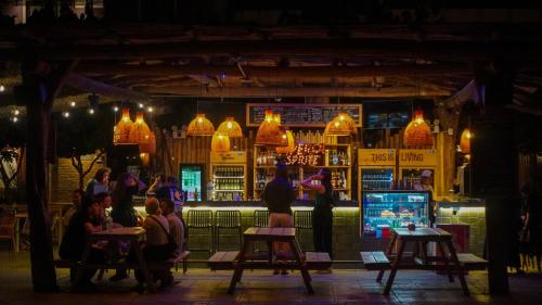 a group of people sitting at a bar at night at Viajero Huacachina Hostel in Ica