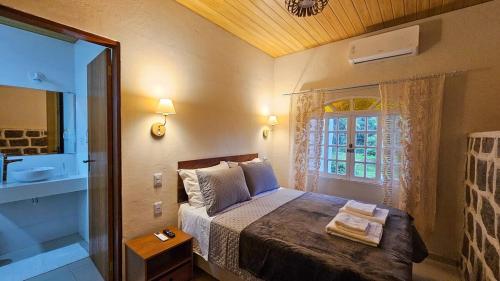 a bedroom with a bed and a bathroom with a window at Recanto da Susanne in Resende