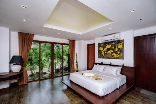 a bedroom with a large bed and a large window at Villa SALSA PRIVATE POOL in Ko Yao Noi