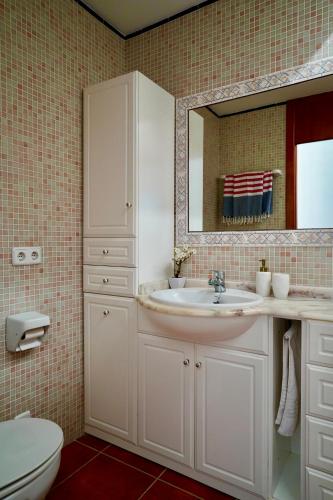 a bathroom with a sink and a toilet and a mirror at Casa Binimel-là con piscina a Cala n'Bosh Menorca in Cala en Bosc