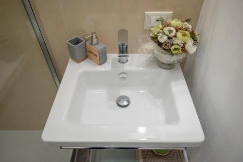 a white sink with a vase of flowers on it at B&B Corso Diaz in Ravenna