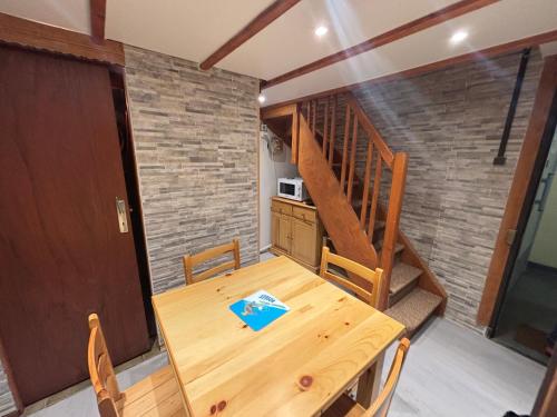 une salle à manger avec une table en bois et un escalier dans l'établissement Résidence Belle Hutte 2, à La Bresse