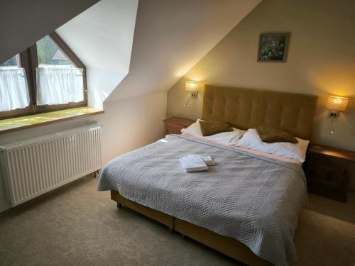 a bedroom with a large bed with two windows at Wellness Pension 7 in Harrachov