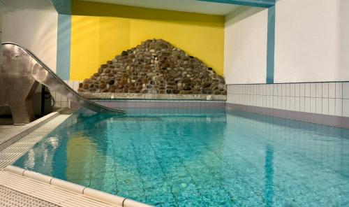 una piscina cubierta con un tobogán en un edificio en Apartment 12 - Ferienresidenz Roseneck, 2 Schlafzimmer, mit Schwimmbad in Todtnauberg bei Feldberg, en Todtnauberg