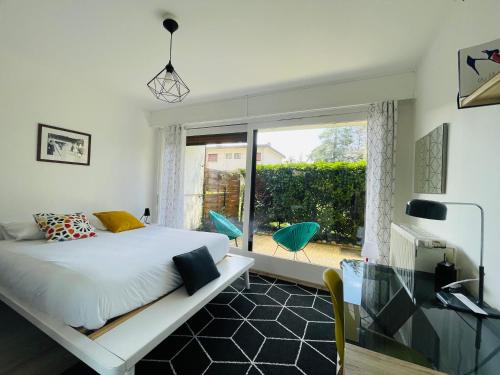 une chambre avec un lit et une porte coulissante en verre dans l'établissement le Nid des Cèdres, voisin des Thermes et du centre, à Thonon-les-Bains