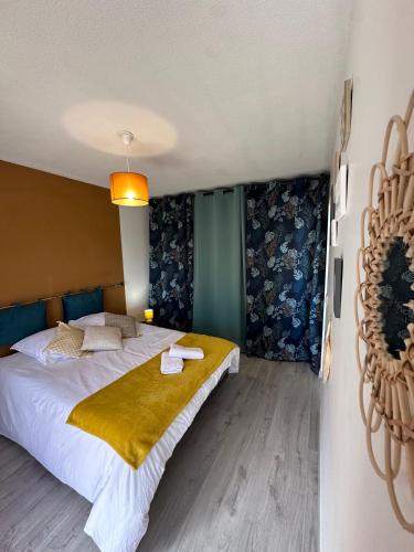 - une chambre avec un grand lit et une couverture jaune dans l'établissement LE COLORÉ - Parking gratuit - Confortable, à Pau