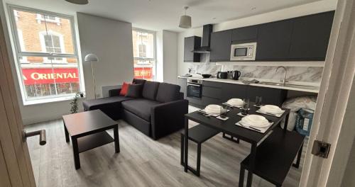 a small living room with a couch and a table at 2BR Apartment with Sofa bed I Prime Town Centre Location I Gold St D-Lux, Modern Amenities, Walk to Train, Bus Stations, Shops & Cafés I Leisure and Business Stays Welcome in Northampton