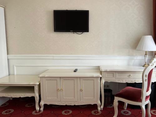 a room with a desk and a tv on the wall at Royal Grand Hotel in Kyiv