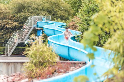 a boy on a slide at a water park at Veluwepark De Bosgraaf | Luxe & Wellness in Lieren