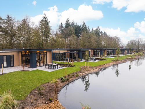 a house with a river in front of it at Veluwepark De Bosgraaf | Luxe & Wellness in Lieren