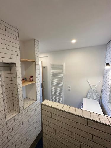 La salle de bains est pourvue d'un mur en briques et d'un lavabo. dans l'établissement LE COLORÉ - Parking gratuit - Confortable, à Pau