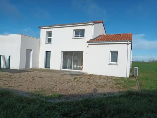 a white house with a field in front of it at gîte maison d'Anetz in Anetz