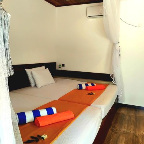 a bed with two pillows on it in a room at Dramatic Green Cottage in Udawalawe