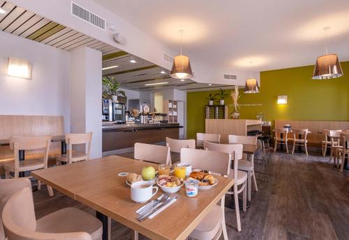 une salle à manger avec une table sur laquelle se trouve de la nourriture dans l'établissement B&B HOTEL La Rochelle Centre, à La Rochelle