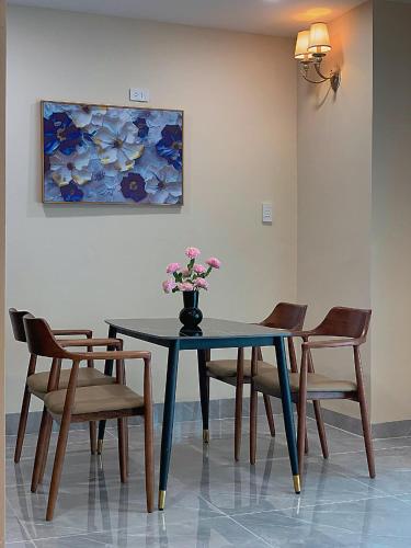a table with chairs and a vase with flowers on it at Diamond Sea Hotel in Vung Tau