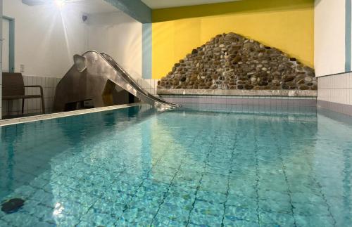 a swimming pool with a slide in a building at Apartment 16 - Ferienresidenz Roseneck, Galeriewohnung, mit Schwimmbad in Todtnauberg bei Feldberg in Todtnauberg