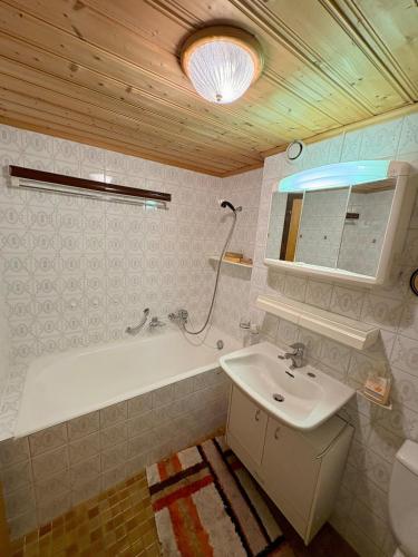 a bathroom with a sink and a bath tub at Studio Valaisia 45a in Nendaz